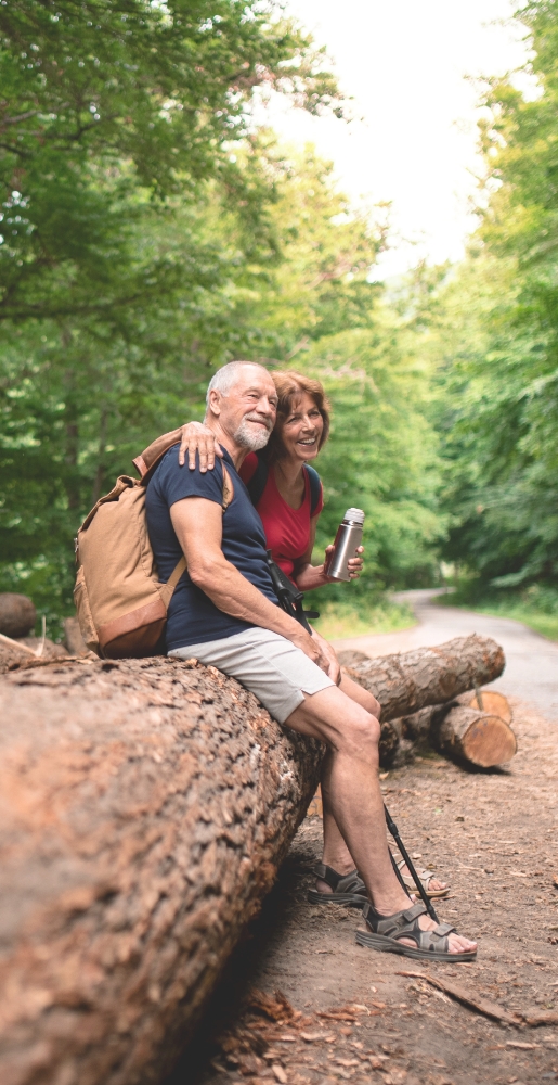 couple on hike resting on log