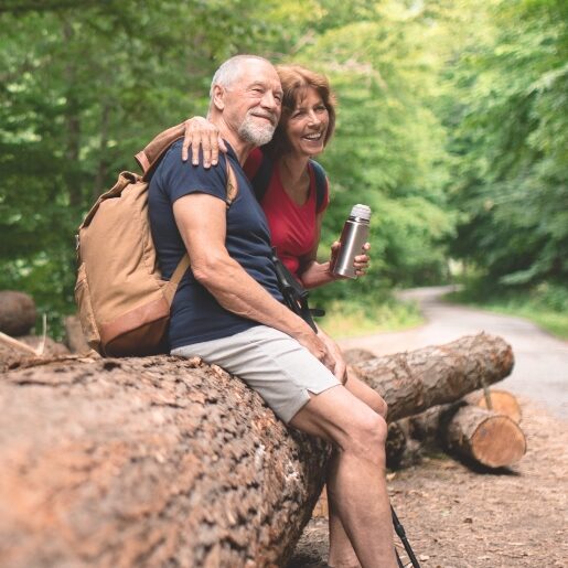 couple on hike resting on log